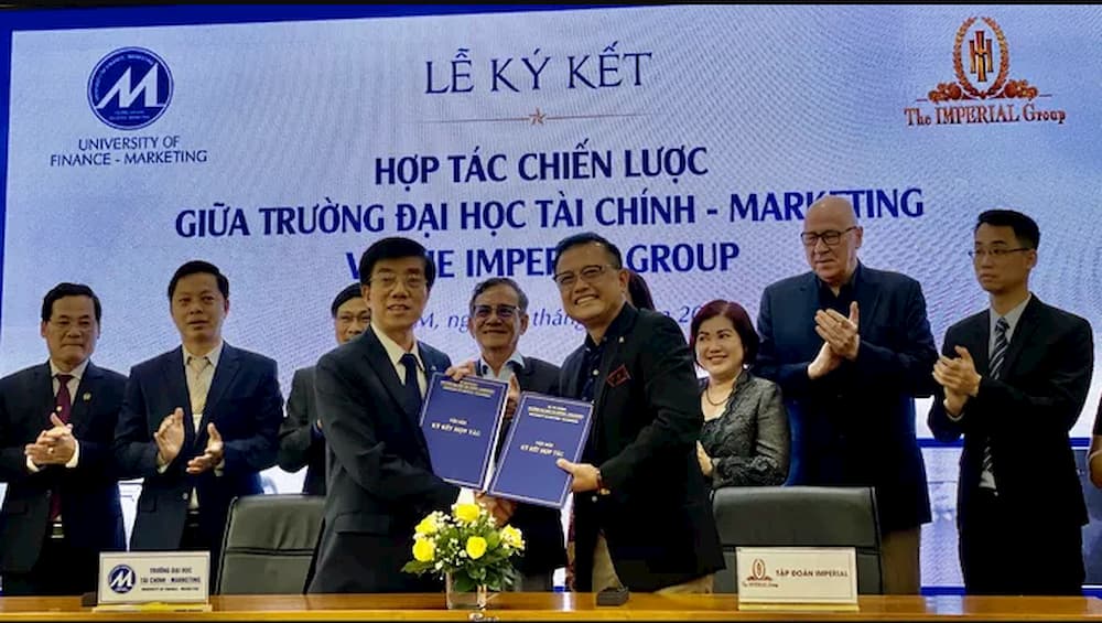 TS Hoàng Đức Long (hàng đầu, trái), Hiệu trưởng Trường ĐH Tài chính- Marketing và ông Huỳnh Trung Nam, Chủ tịch tập đoàn Imperial trao đổi biên bản ký kết